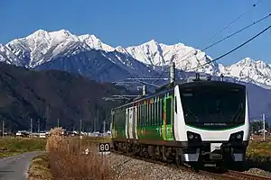 北アルプスを背景に大糸線を走るHB-E300系「リゾートビューふるさと」(2022年12月 安曇沓掛駅 - 信濃常盤駅間)