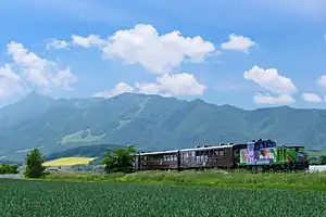 夕張山地をバックに走る富良野・美瑛ノロッコ号(2022年6月 鹿討駅 - 学田駅間)