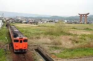 最上稲荷の大鳥居をバックに備中高松駅を発車するキハ47形。
