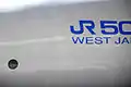 W1編成 側面に対向列車のすれ違い試験時に取付けられたセンサー窓が見られる（JR500ロゴのすぐ前側にある黒丸がセンサー窓）
