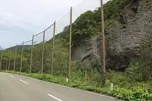 県道沿いに設置された落石防止ネット。節理の上部はentablature構造。2022年9月8日撮影。