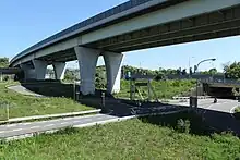 画像左 :構想では名阪国道の起点は国道1号と国道25号が分合流する関町新所付近が想定された。画像右：クローバー型のランプウェイの造成は小山の地形を利用した。