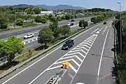 料金所へのランプウェイは隣接する亀山パーキングエリアまで到している。