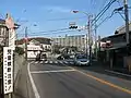 塚場交差点。手前が起点方面で左が終点方面。右は県道63号。