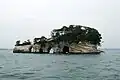 鐘島。4つの洞門に打ち寄せる波が鐘の音のように聞こえたことが名の由来。