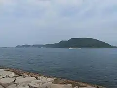 湊港地先の女瀬ノ鼻から望む神集島。島に向かう白い船は定期船「荒神丸」。