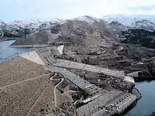 山岳の景色の中にある巨大なダムと排水溝
