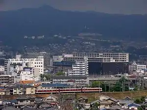 関西本線との交差部をゆく8400系。後方は信貴山。(大輪田駅 - 新王寺駅間)