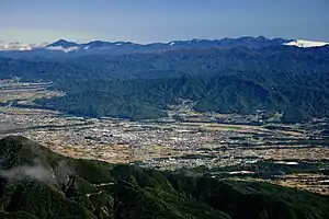 南西側の烏帽子岳から望む駒ヶ根市の街並み、その背後に伊那山地、さらに背後に赤石山脈と八ヶ岳