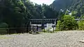 駅名標。奥に小屋平ダムが見える。