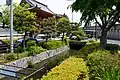 昆陽寺山門前を東向きに流れる昆陽井。奥の国道171号線は暗渠でくぐる。写真の箇所で南側の山田用水に向けて水を落とす機構が存在する