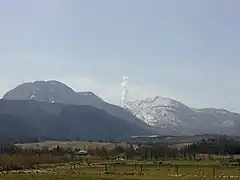 1995年噴火時の様子。星生山（右）と三俣山（左）。中央の噴煙は硫黄山から上っている。