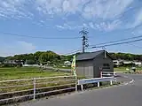 岡田の風景左から3番目(茶色い壁の家の右後方)に金剛寺の鐘楼、その右に横溝正史疎開宅、画面右端に濃茶の祠が見える。