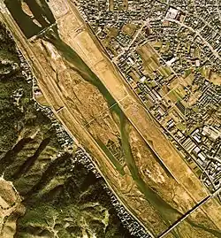 明王台およびそれ以東（河口から約8km付近）。写真上から右下へ伸びる道路が旧・鷹取川の名残。写真当時（1974年）は中洲で草戸千軒発掘が行われている。発掘のため制限しているとはいえ流量不足が確認できる。
