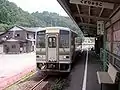 九頭竜湖駅で発車を待つ美山行き表示の旧塗装のキハ120形気動車（2005年7月）