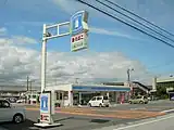 南国ごめん町駅店（高知県南国市）。ローソンの看板の下に緑色の字で土電ごめん町と書かれているのが電停と併設されていることを表している。
