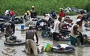 現代のアフリカ、象牙海岸、アビジャンの川で洗濯をする男性たち(2006年)