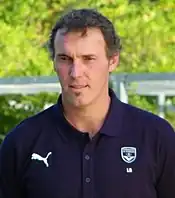 A dark-haired man wearing a black shirt.