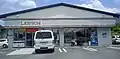 桜島店（鹿児島県鹿児島市）。桜島の景観を損なわないために、店舗の看板などに白色と茶色を使用している。降灰するため屋根に傾斜が付き、雨といが無い。なお、当店舗は閉店した。