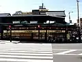 旧八坂神社前店（京都府京都市東山区）。向かいに八坂神社があり、歴史的景観を損わないようにするため、看板を白地に黒文字のデザインとしている。2018年閉店。