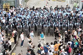 12日朝、機動隊の目の前で祈りを続ける市民