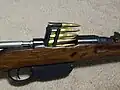 M1895小銃にエンブロック・クリップを挿入する様子。最終弾が薬室へ装填されると、使用済みエンブロック・クリップは弾倉の下面にある排出口から自重で落下する