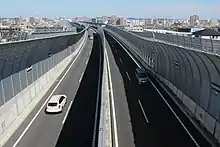 画像左:名二環は高速自動車国道であるが、東名高速や東名阪自動車道と比べると設計速度は60 km/hと低く、道路幅員も狭いなど低規格である(名古屋市天白区)。画像右:名二環のインターチェンジは人口密集地帯の都市圏に敷設されることからハーフダイヤモンド型が主流である(松河戸IC)。