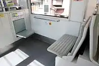台車上部分の座席(左)と運転台後部の座席(右)。座席のモケットは第4編成以降が青色(左)、第3編成までが鶯色(右)(2016年6月)