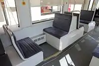 台車上部分の座席(左)と運転台後部の座席(右)。座席のモケットは第4編成以降が青色(左)、第3編成までが鶯色(右)(2016年6月)