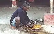 香辛料を挽いてカレー粉を作るインド人