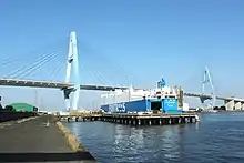 東海 - 金城ふ頭間に建設された名港中央大橋（左）と名港東大橋（右）。1987年（昭和62年）11月に一般有料道路事業として事業許可された。1985年（昭和60年）開通の名港西大橋と併せて、豊田 - 四日市間の全線に先駆けて事業化されたことが後年、伊勢湾岸自動車道の東海 -  飛島間のみが一般有料道路として存在する遠因となった。