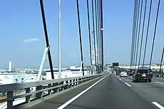 画像左:横から見たケーブル連結部。その間隔は端部になるほど密になる。画像右:一期線は車両衝突におけるケーブル保護のため防護ステイが斜めに設置された。