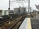 駅の西にある東名高速架道橋（奥）と渡り線（手前）