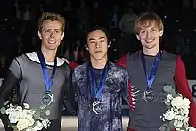 2018年スケートアメリカの表彰式にて、2位のミハル・ブジェジナ、3位のセルゲイ・ボロノフとともに写真に写るネイサン・チェン