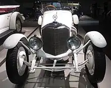 1923年: メルセデス・10/40PS（英語版）。ダイムラー社時代のラジエーターマスコットを装着している。このシンプルな造形が1989年に制定された標章の基となる。