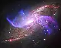 紫の腕は、M106の中心部にある巨大ブラックホールが放つジェットの水素ガスの衝撃波とみられている。