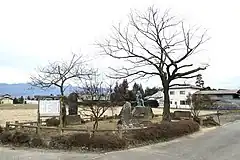 長野県松本市新村にある物くさ太郎伝承地と、そこに立つ物くさ太郎の銅像(右)。