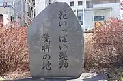橋の北東側河畔にある花いっぱい運動発祥の記念碑。2012年3月21日撮影
