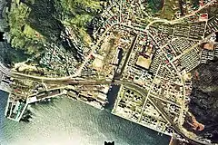 本輪西駅
1976年の本輪西駅と約1.5km×1km範囲。駅舎前からは上の水面貯木場向けと川を渡って右手の各ガス会社向け専用線が伸びる。また駅裏からは左手は本輪西埠頭の土場や倉庫へ、右手は中卯埠頭の油槽所へスイッチバック状に専用線が走る。現在では西側のJX製油所向け専用線以外は廃止されて残っていない。国土交通省 国土地理院 地図・空中写真閲覧サービスの空中写真を基に作成
