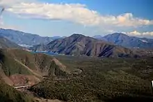 西側の御坂山地のパノラマ台から望む青木ヶ原(左下に国道139号の青木ヶ原大橋)と足和田山、左中央に西湖、その奥に河口湖、右奥に杓子山