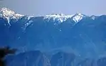 南アルプスの上河内岳と茶臼岳との間の稜線越しに富士山の山頂部