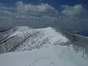 北側のピークの伏拝（標高1,360m）方面から望む法恩寺山の山頂部（左奥）（2005年3月19日）