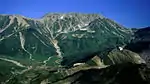 西側からの展望真砂岳と立山（左から富士ノ折立、大汝山、雄山）、左下部に雷鳥沢キャンプ場。下部に山小屋（左から雷鳥荘、雷鳥沢ヒュッテ、みくりが池温泉、右上の稜線鞍部に一ノ越山荘）