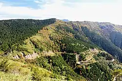 西方の白草山方面から望む三国山（長野県王滝村と岐阜県中津川市）、左端に鞍掛峠（2014年10月11日）