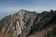 木曽前岳から望む牙岩から山頂にかけて崩落する南西側の斜面