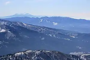 野伏ヶ岳から望むウイングヒルズ白鳥リゾート(中央)その奥に鷲ヶ岳(ホワイトピアたかすと鷲ヶ岳スキー場)、左最奥に御嶽山(2011年4月17日)
