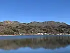 山中湖畔みさきからの逆さ石割山。中央の頂上直下がガレているのが石割山。頂上脇を東電の高圧線が通る。