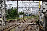 武蔵白石駅から安善駅方面を見る。遠方に見えるのは在日米軍鶴見貯油施設の留置線、左側に見える分岐線は大川方面に向かう支線と浜川崎貨物駅から安善駅の留置線に向かう線路である。（2010年9月）
