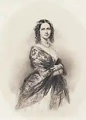  photograph of Victorian woman in dress and shawl, pearl necklace, body facing right, smiling face facing viewer