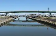 河川の両岸に橋脚を設置（新川）。東海豪雨により決壊した堤防は橋の向こう左側。